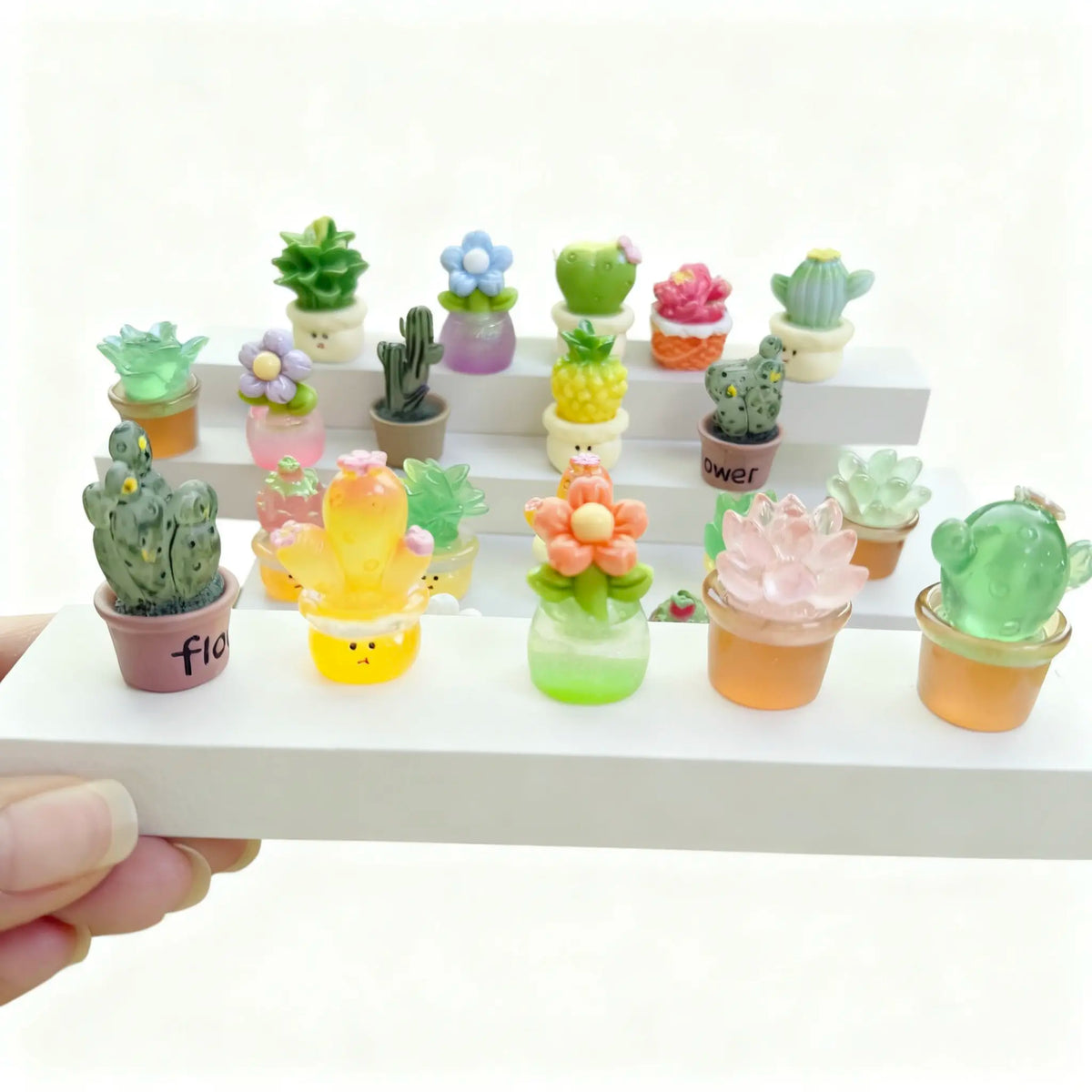 Palm-sized mini resin plants shown for scale